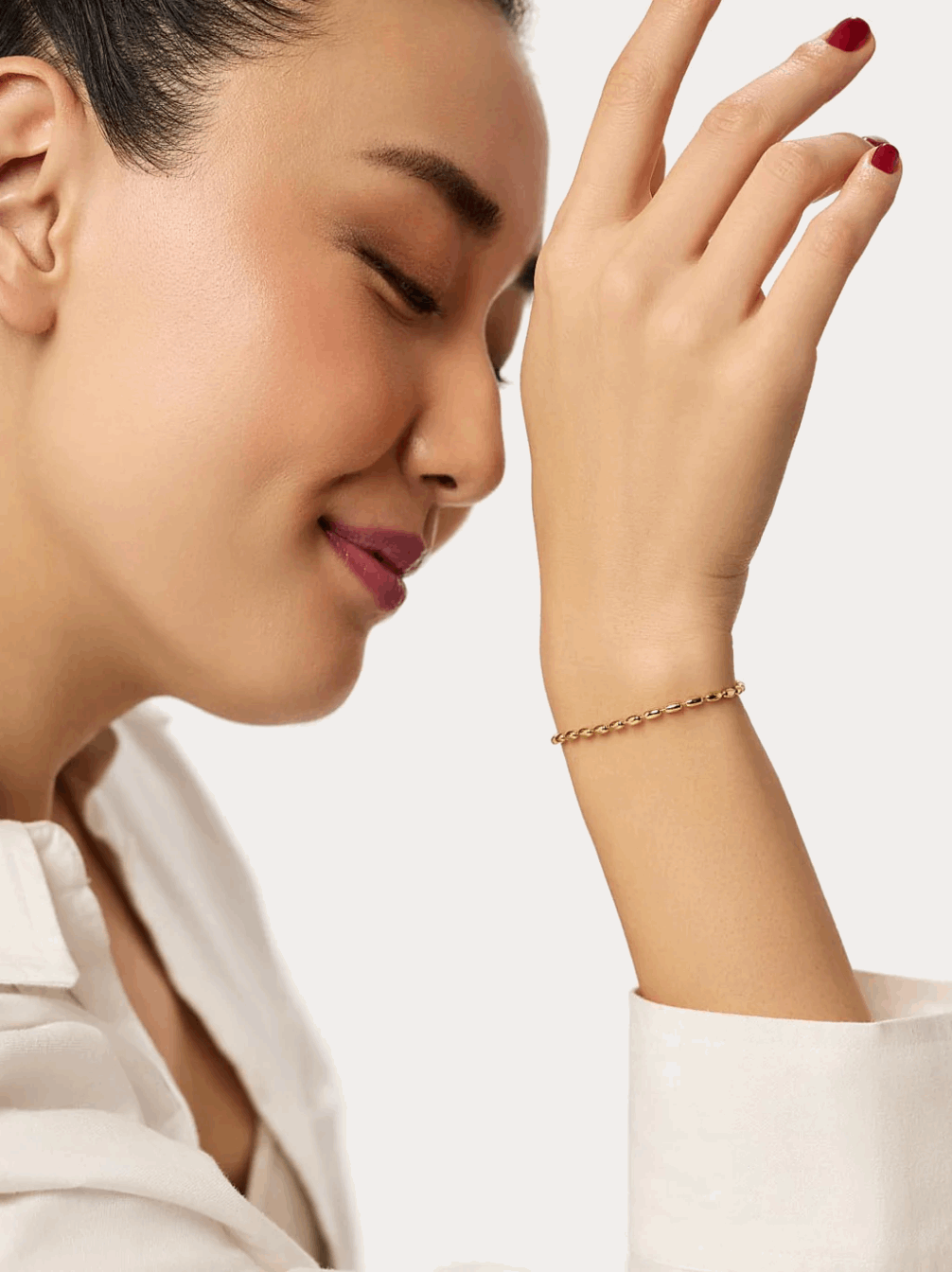 Gold bead bracelet around girls raised wrist