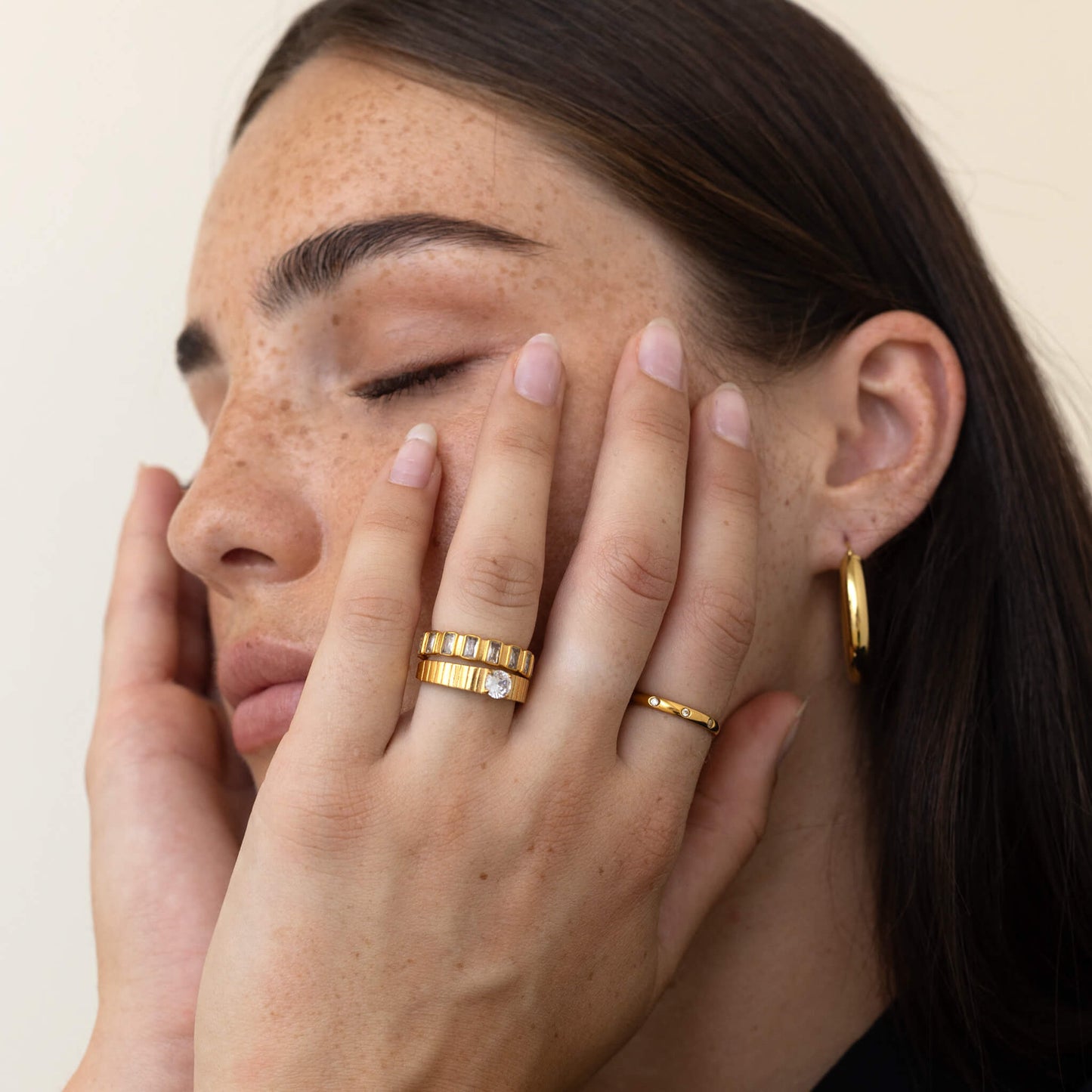 Crystal strength ring on index finger with other rings