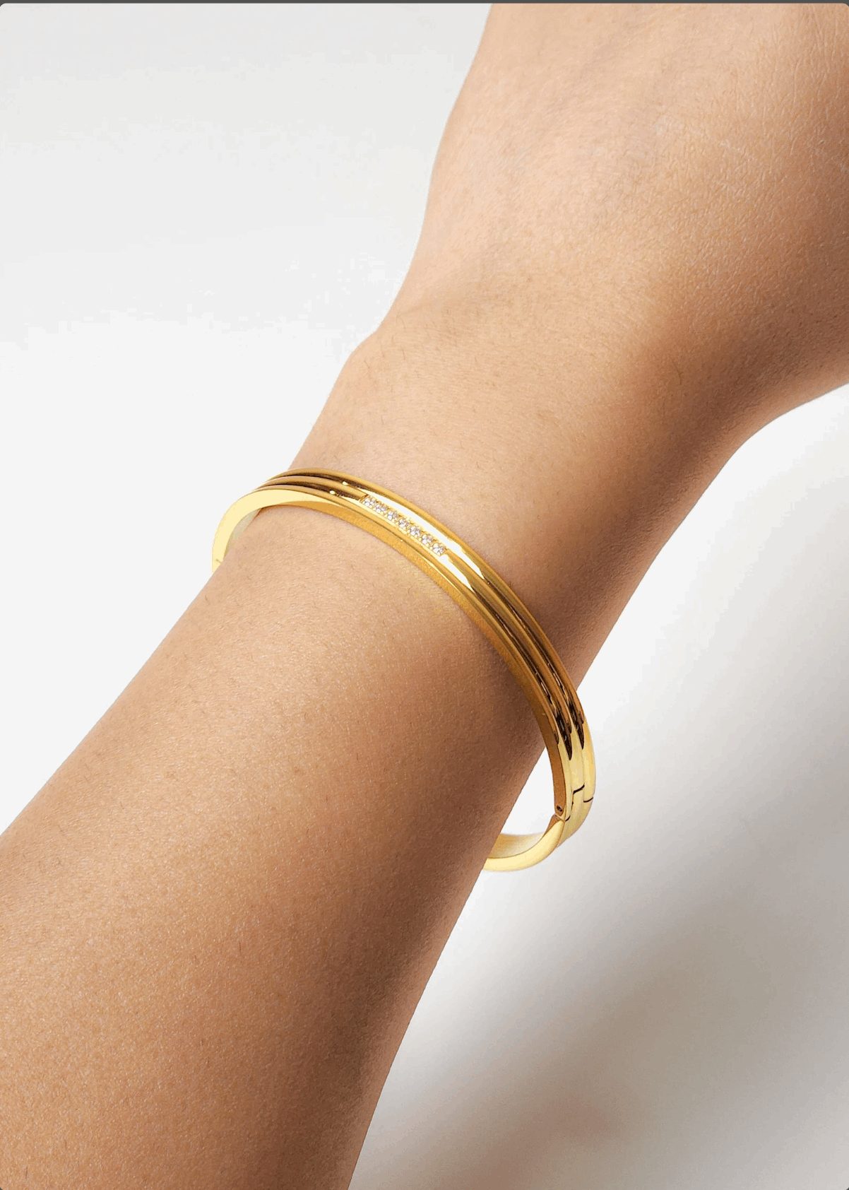 18K Gold crystal bracelet around girls wrist, sun shining on bracelet