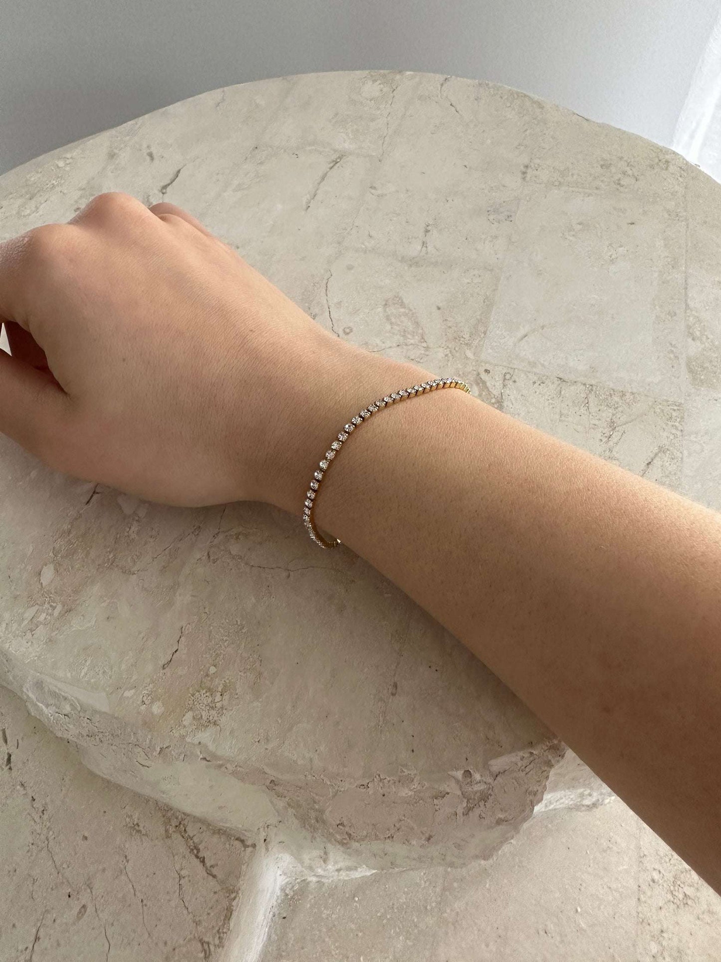 Cubic Zirconia Tennis bracelet on girls wrist, resting on rock