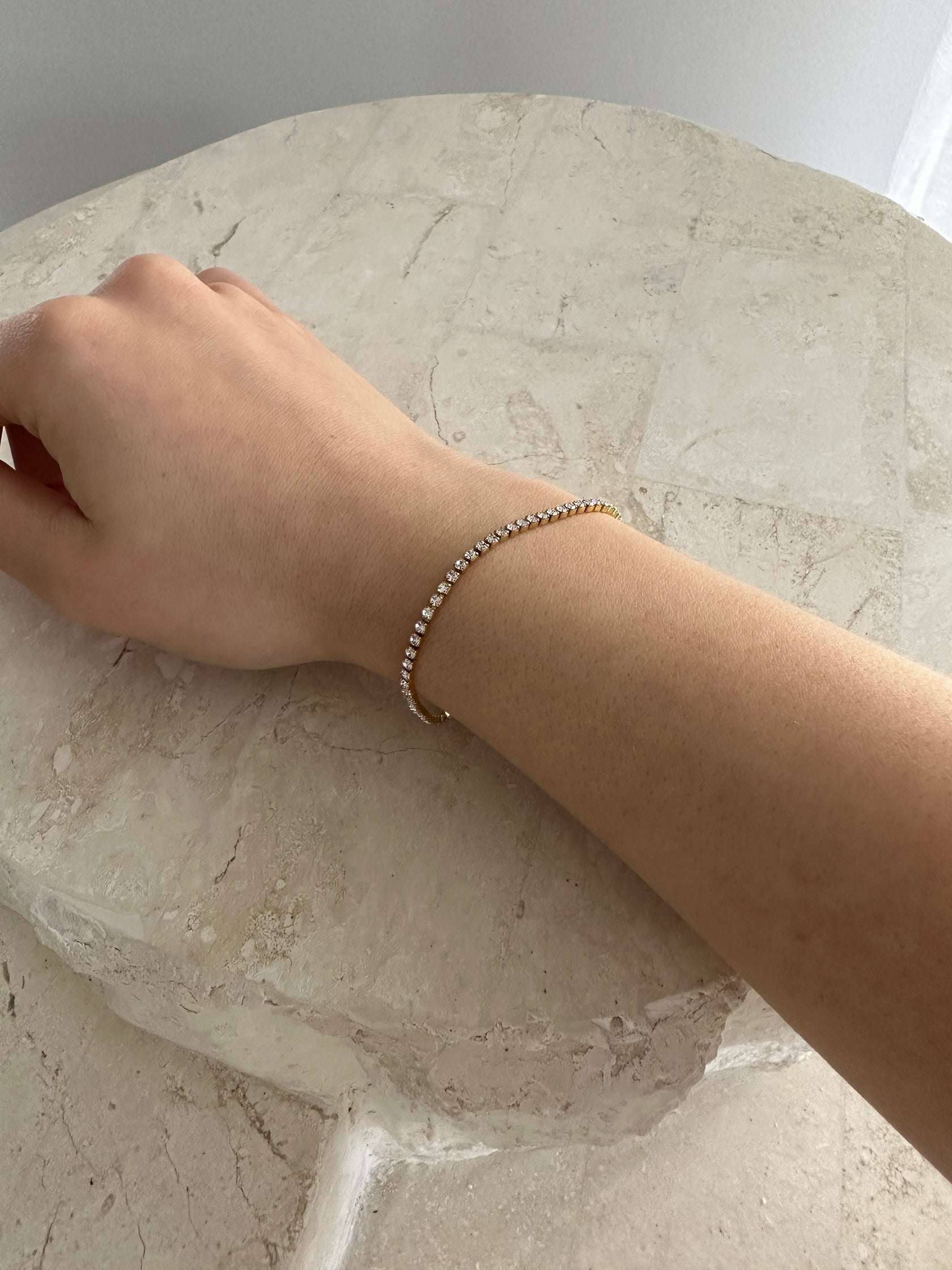 Cubic Zirconia Tennis bracelet on girls wrist, resting on rock