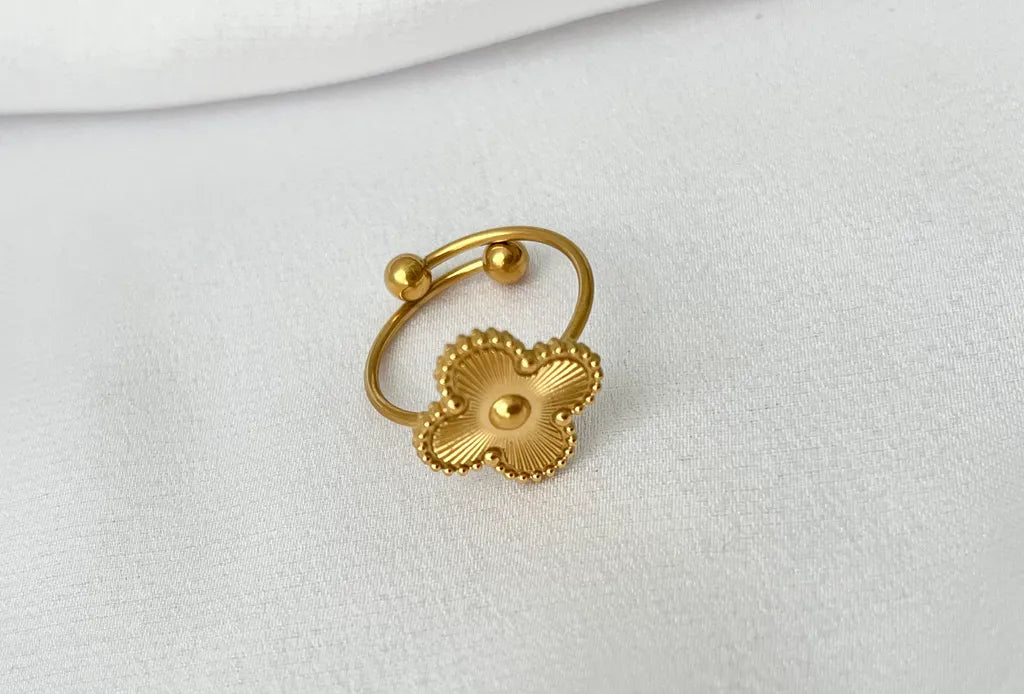 Gold Four Leaf Clover Ring - resting on surface