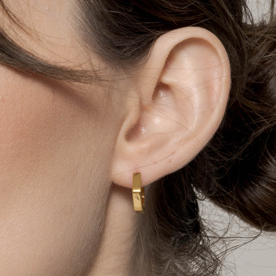 Gold Hex Huggie Earring on Left Ear Zoomed In