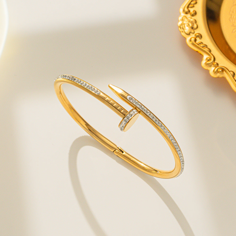 Gold Nail Bracelet with Crystals, upright on surface
