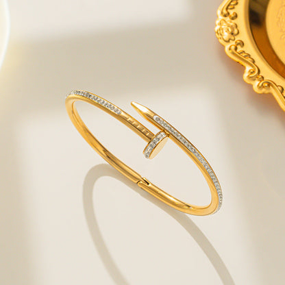 Gold Nail Bracelet with Crystals, upright on surface