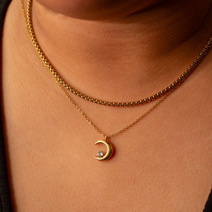 Moon crystal necklace resting aorund tanned girls neck