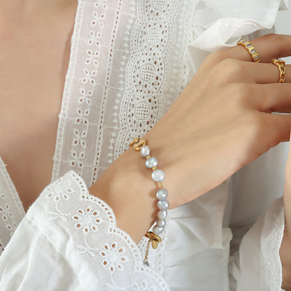 gold pearl bracelet on girls raised wrist