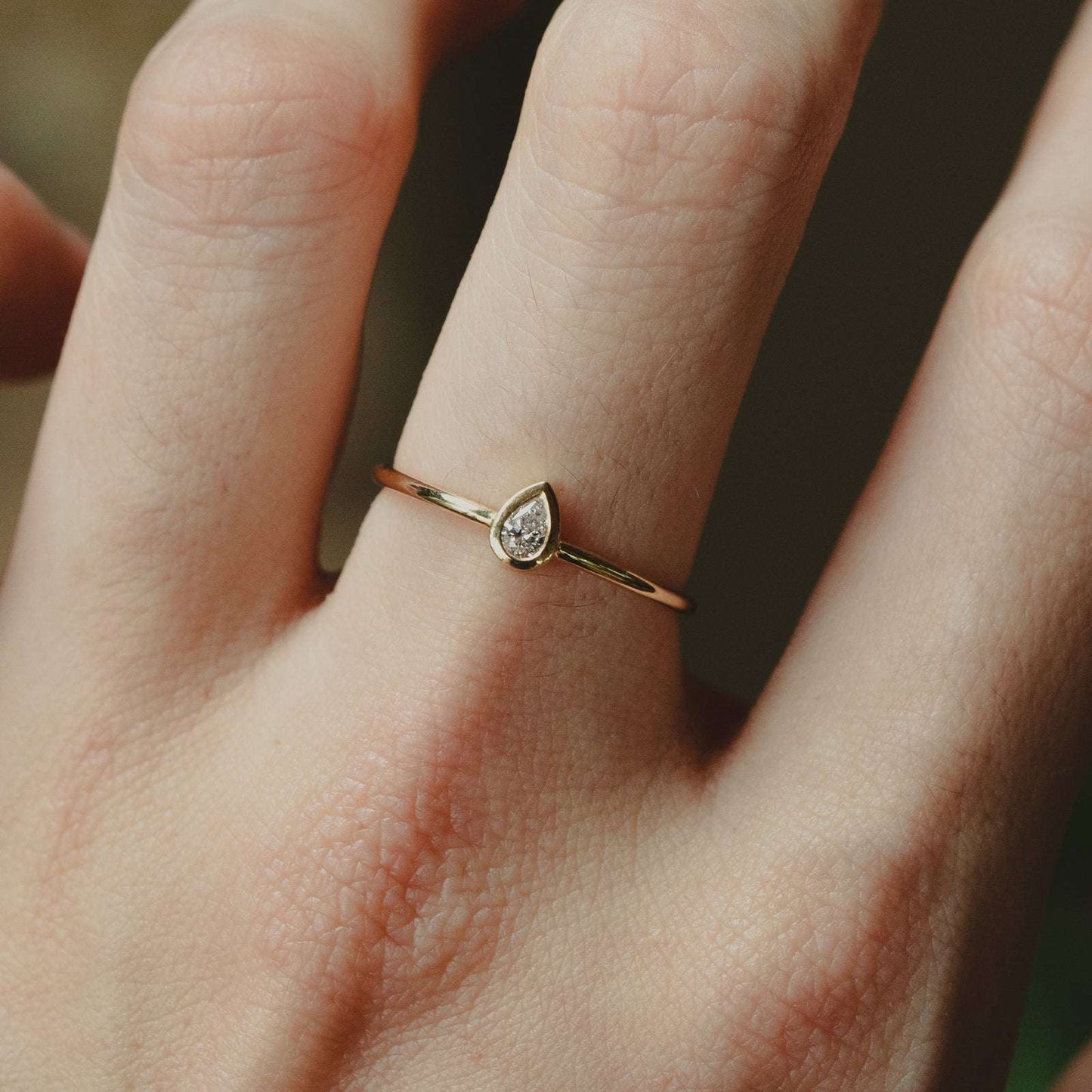 Pear Shaped Crystal Ring - Cubic Zirconia Gold Ring on middle finger, closeup