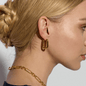 Gold oval huggie earrings on right ear